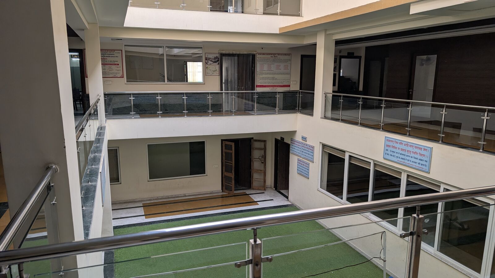 An interior atrium with galleries on two floors and glass balustrades